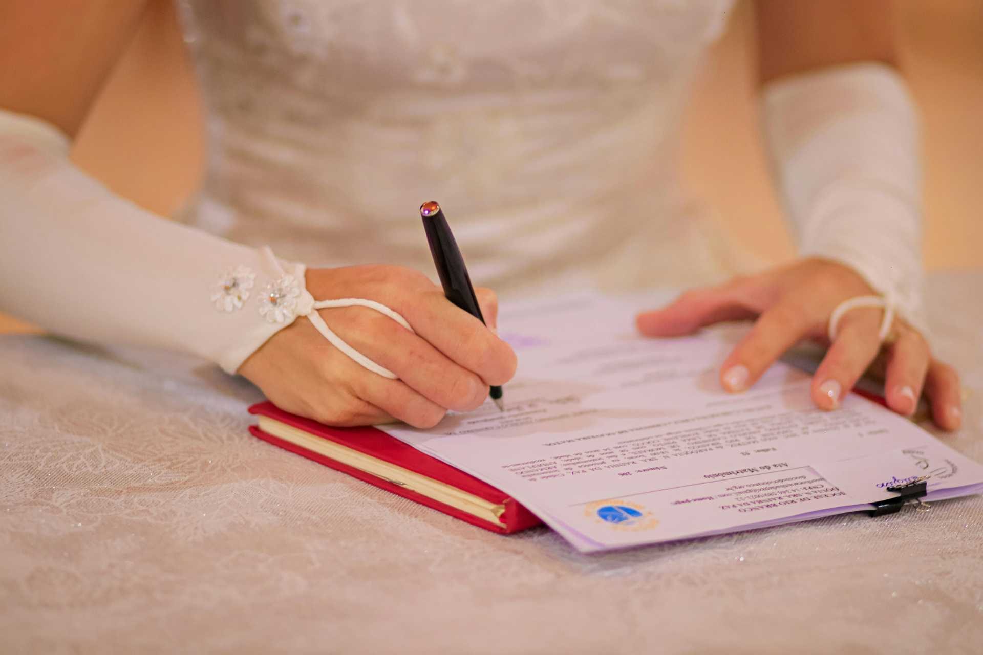 Bride signing a document on a table
