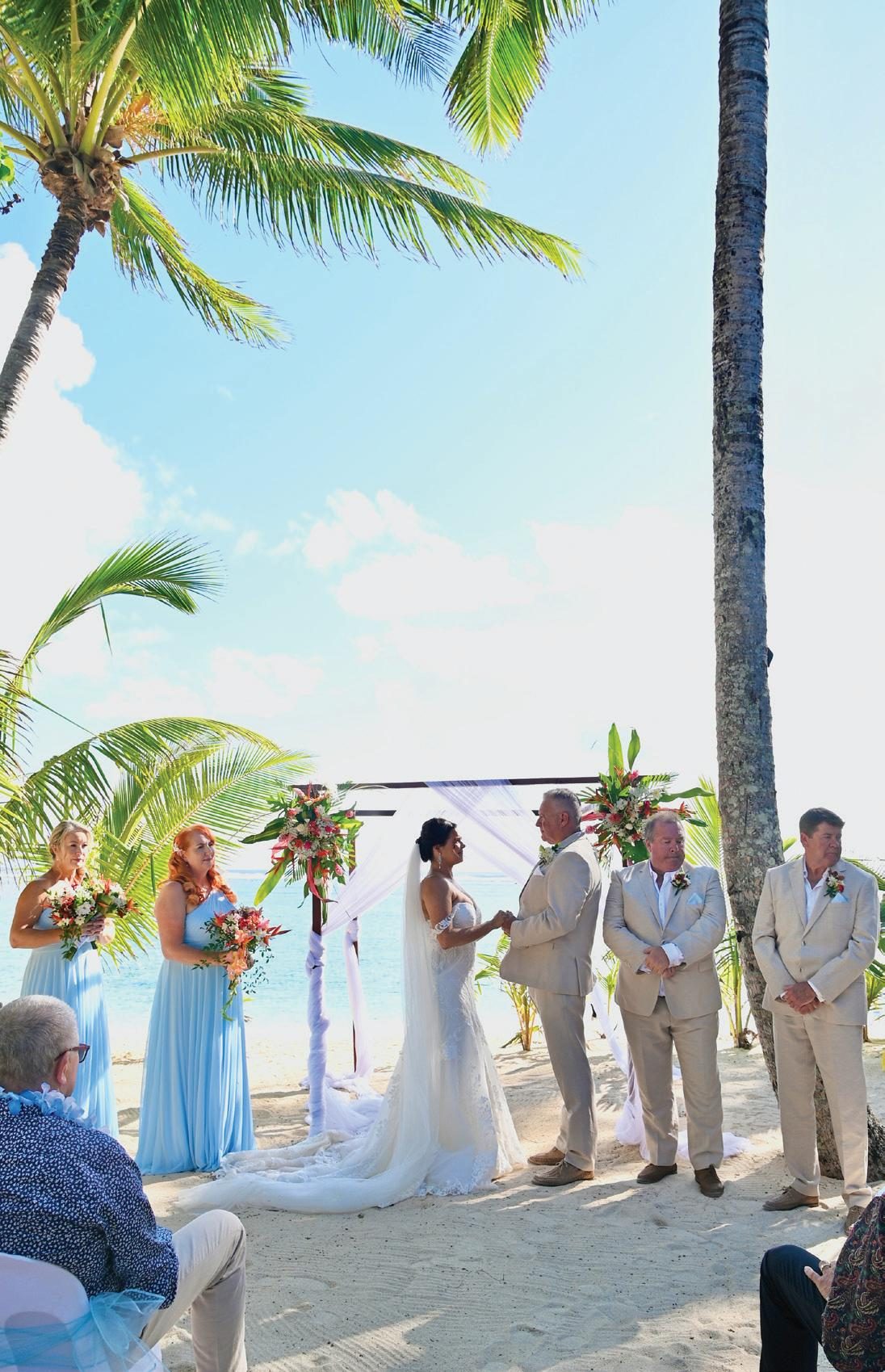 Bride and groom getting married on a beach with their wedding party