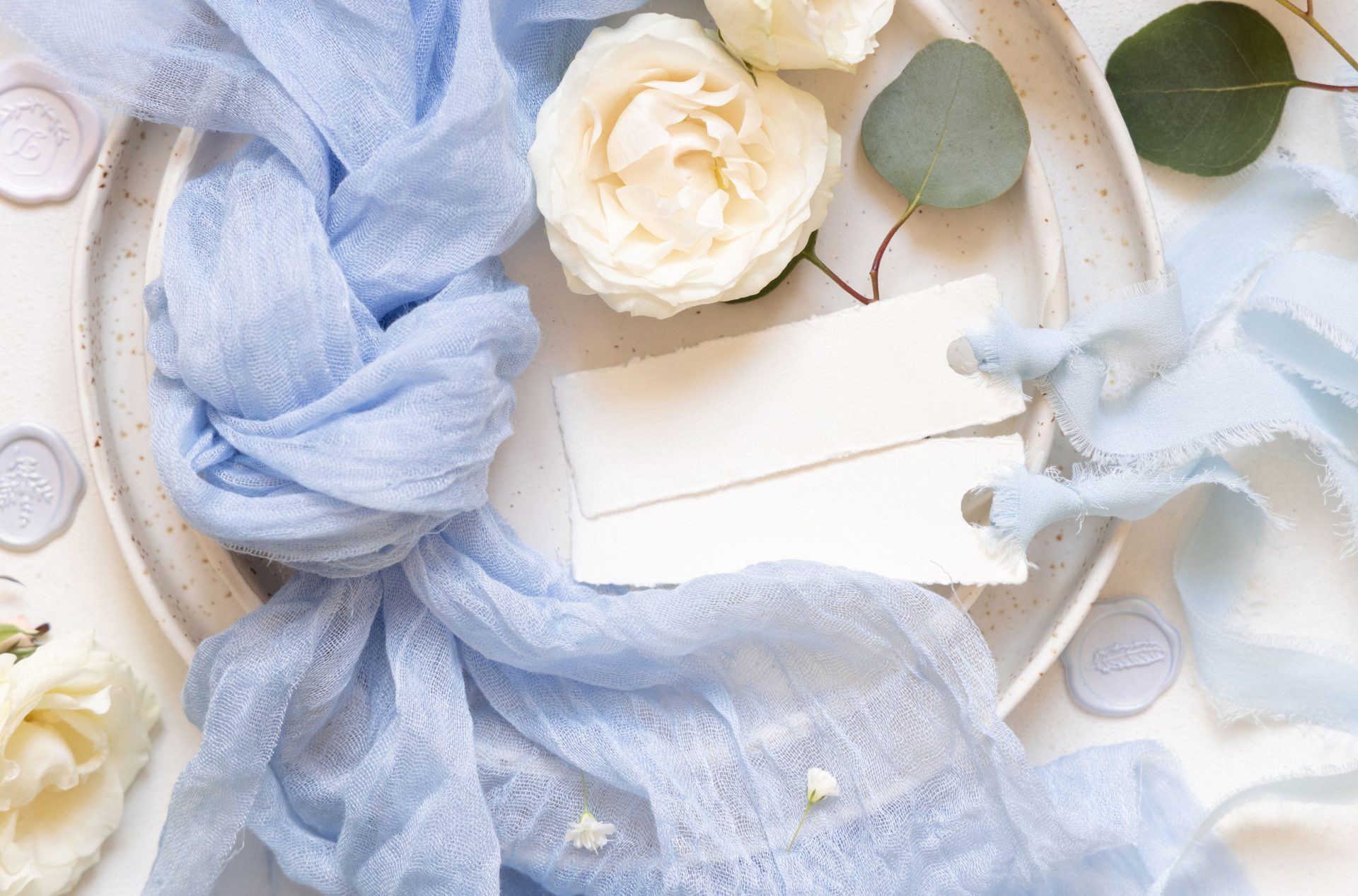 cards-near-light-blue-fabric-and-cream-flowers